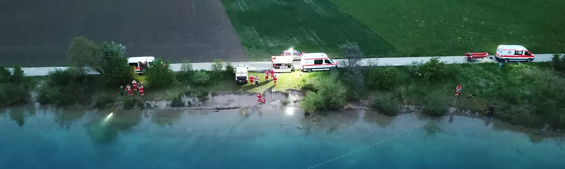 Übung der Schnelleinsatzgruppe am Seeufer bei Dämmerung aus der Luft