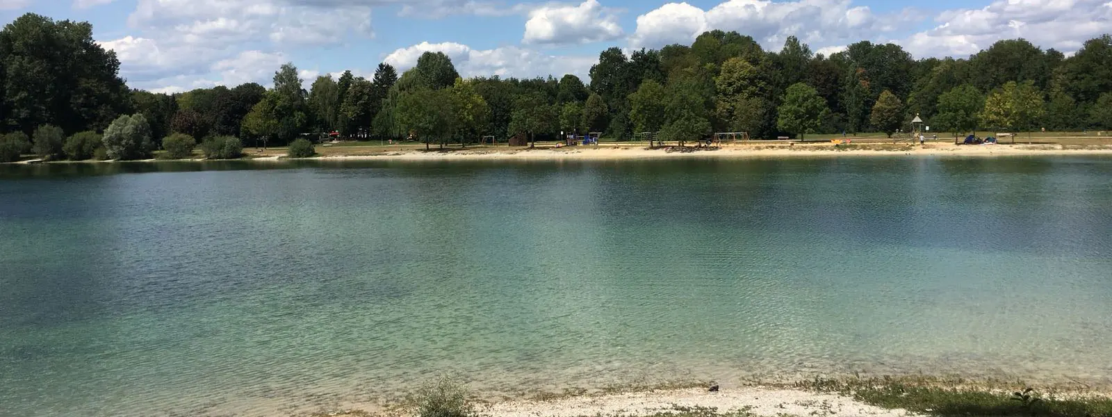 Der Autobahnsee Augsburg mit klarem Wasser und Liegewiese