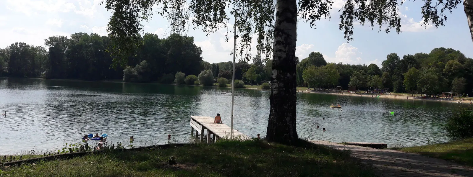 Badegäste und Steg am Autobahnsee